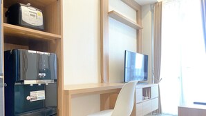 Eine kompakte Küchenzeile mit Kühlschrank, Mikrowelle und kleinem Backofen.