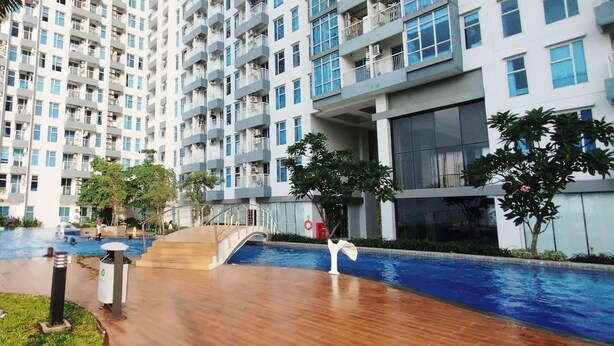 Un immeuble résidentiel doté de nombreux balcons, d’une piscine et d’un espace extérieur couvert.