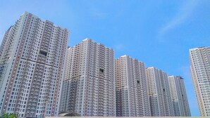 Un immeuble résidentiel de grande hauteur, doté de nombreux étages, de grandes fenêtres et de balcons.