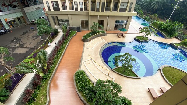 Ein Hotel mit Schwimmbad, überdachtem Gang und angelegtem Garten.