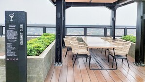 A covered outdoor seating area with a view of the cityscape.