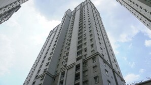 A high-rise building with multiple floors and balconies, featuring a modern architectural design. - Comfort Stay Studio Grand Palace Kemayoran Apartment (Jakarta)