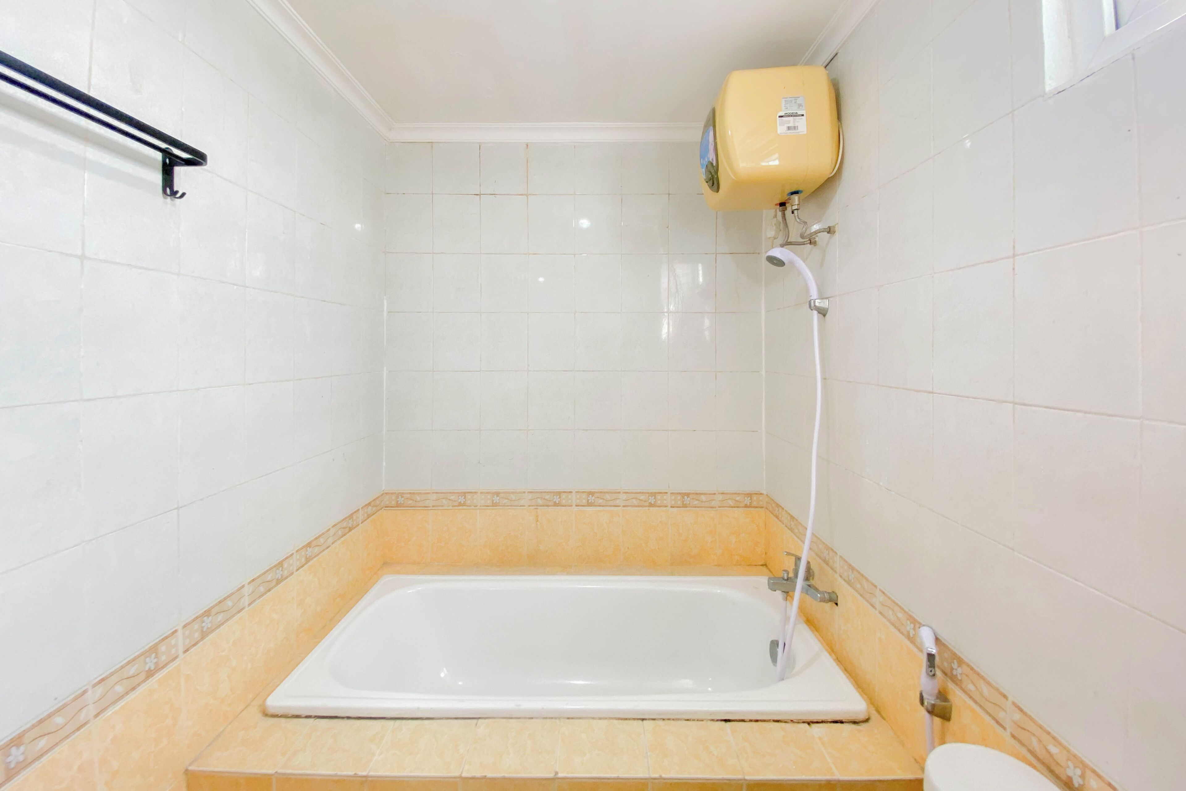 A bathroom with a bathtub, a toilet, and a water heater.