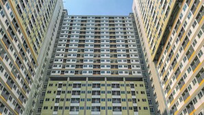 A high-rise residential building with multiple balconies and a uniform facade. - Cozy And Restful Studio Lrt City Sentul - Royal Sentul Park Apartment (Bogor)