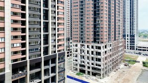 A high-rise residential building with multiple floors, balconies, and a construction site nearby. - Clean And Homey 2Br At Meikarta Apartment (Cikarang)
