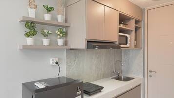 Studio | Privékeuken | Een koelkast met diepvriezer, een microgolfoven, een kookplaat