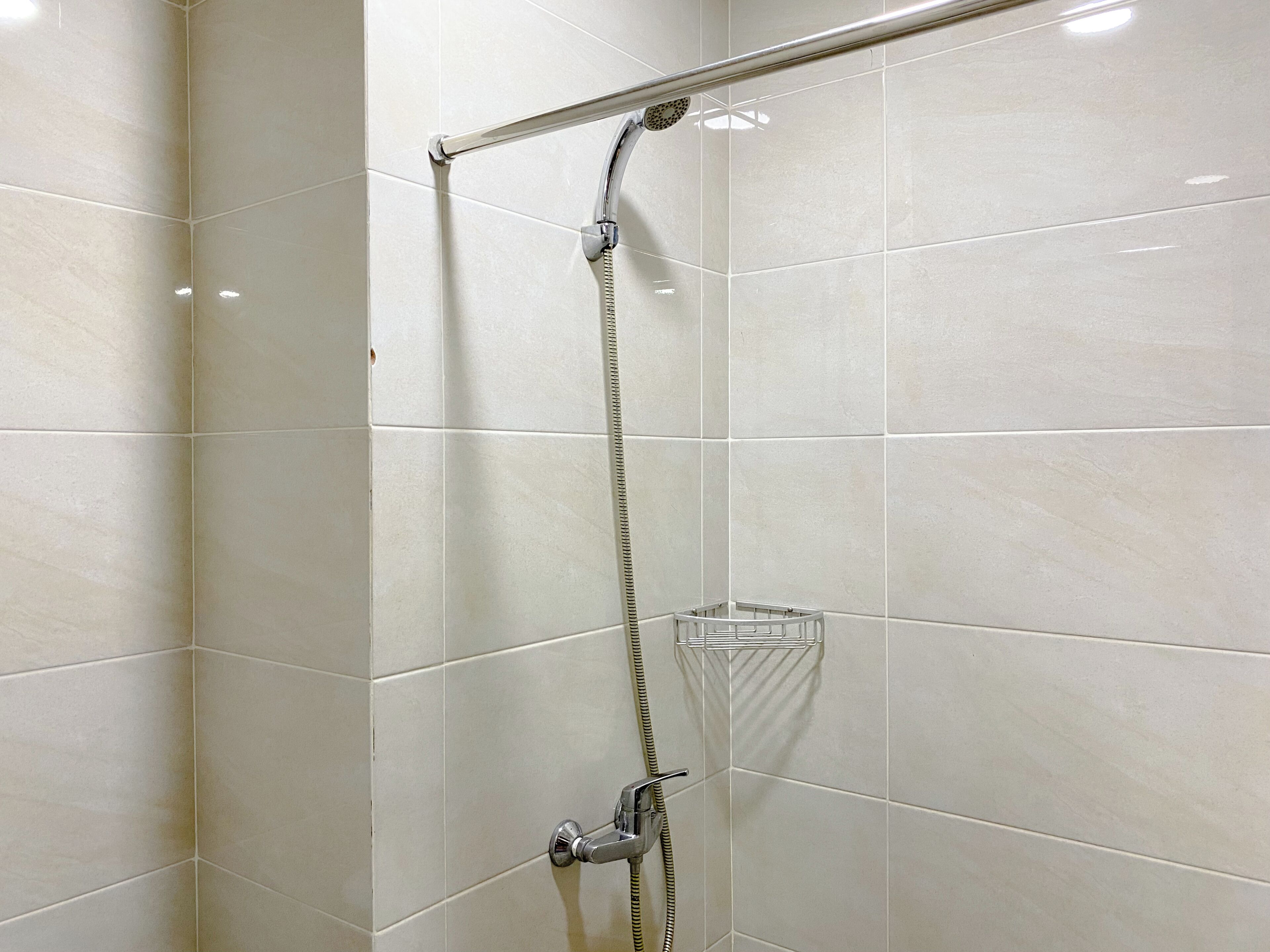 Une douche équipée d’un pommeau de douche et d’un robinet à main.