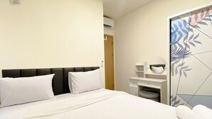 Ein Hotelzimmer mit einem Bett, einem Nachttisch, einem Spiegel und einem Kleiderschrank.
