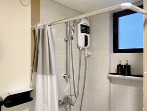 Ein modernes Badezimmer mit Dusche, einer digitalen Duschbrause und einem Fenster.