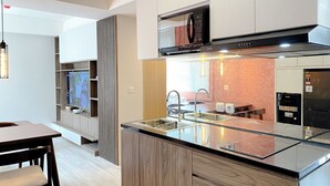 A modern kitchen with a central island, built-in microwave, and stainless steel appliances.