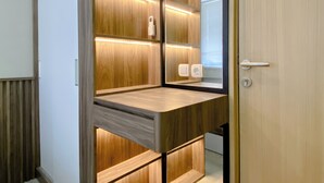 A modern bathroom with wooden paneling, built-in shelves, and a mirror.