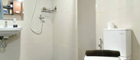 Un baño con inodoro, lavabo y ducha.