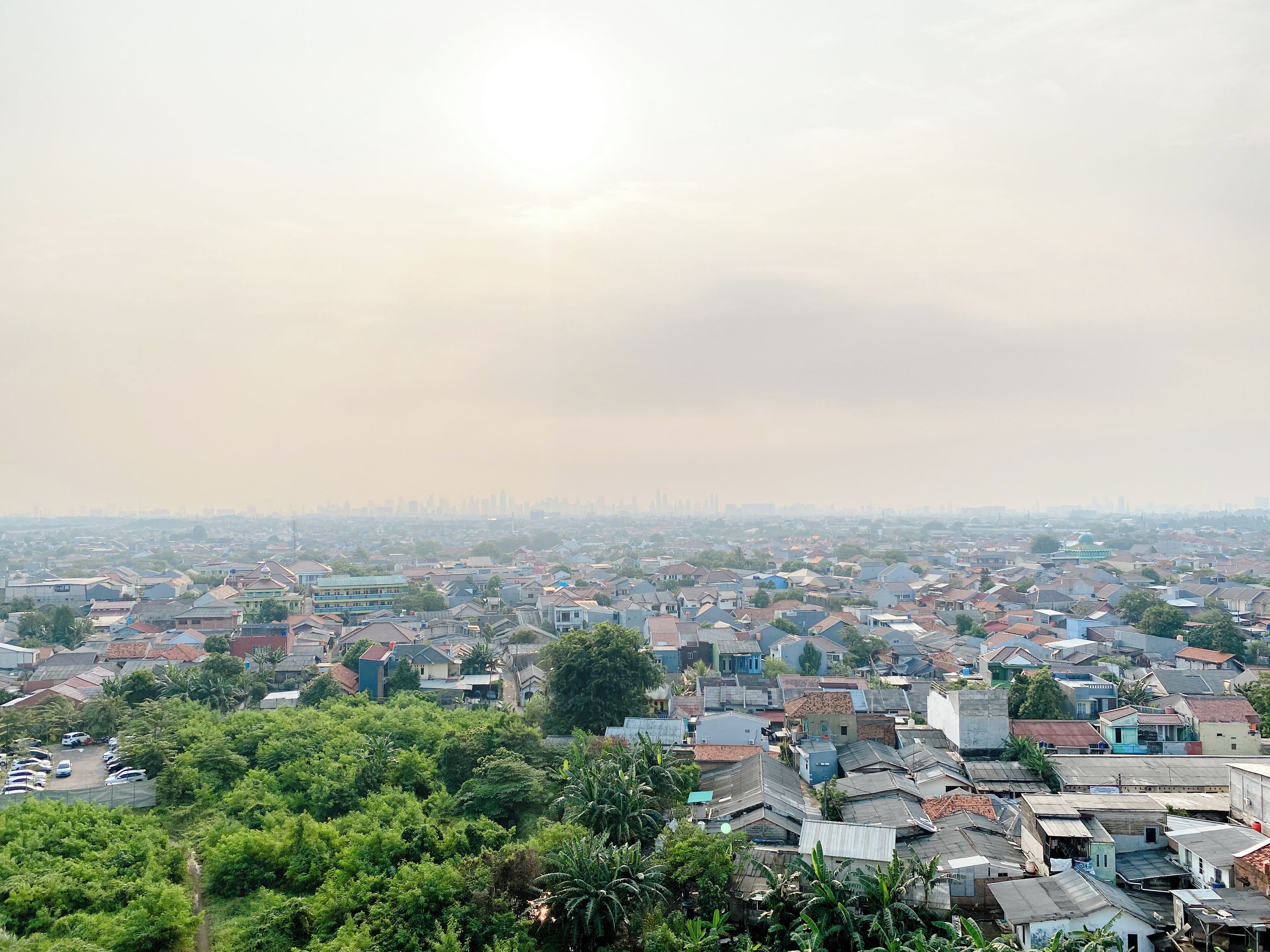 A densely packed urban area with numerous residential buildings and a distant city skyline.
