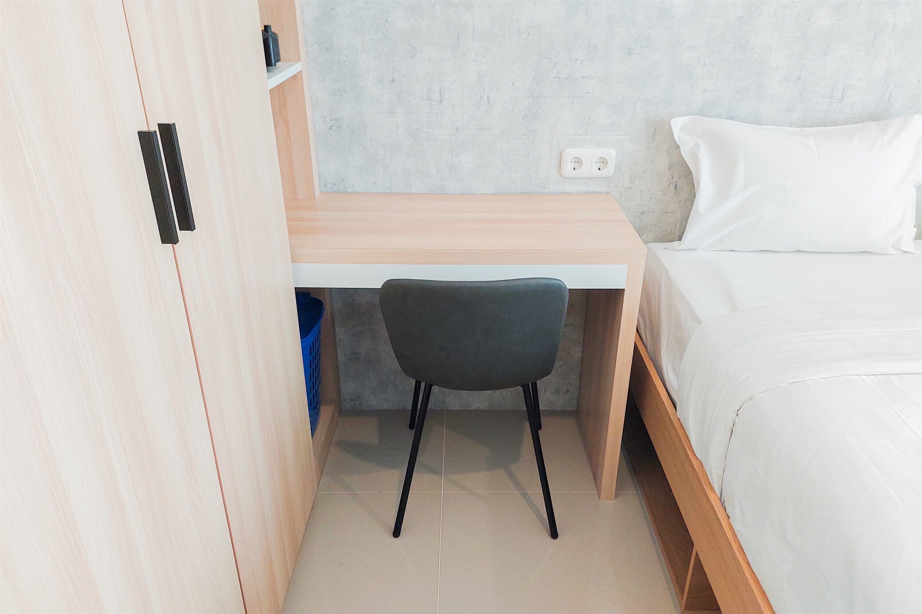 A bedroom with a bed, a desk, and a chair.