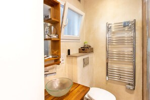 Bathroom features a glass bowl sink, white toilet, and chrome towel rack.