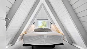 A bedroom with a bed in a sloped ceiling room, featuring a window and a door. - Nice home in Farsø with kitchen (Farsø)