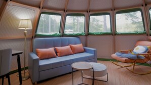 A cozy interior with a sofa, a small round table, and a rocking chair. - Countryside Getaway Green UniqueDomeA/serene farm retreat (Snow Camp)