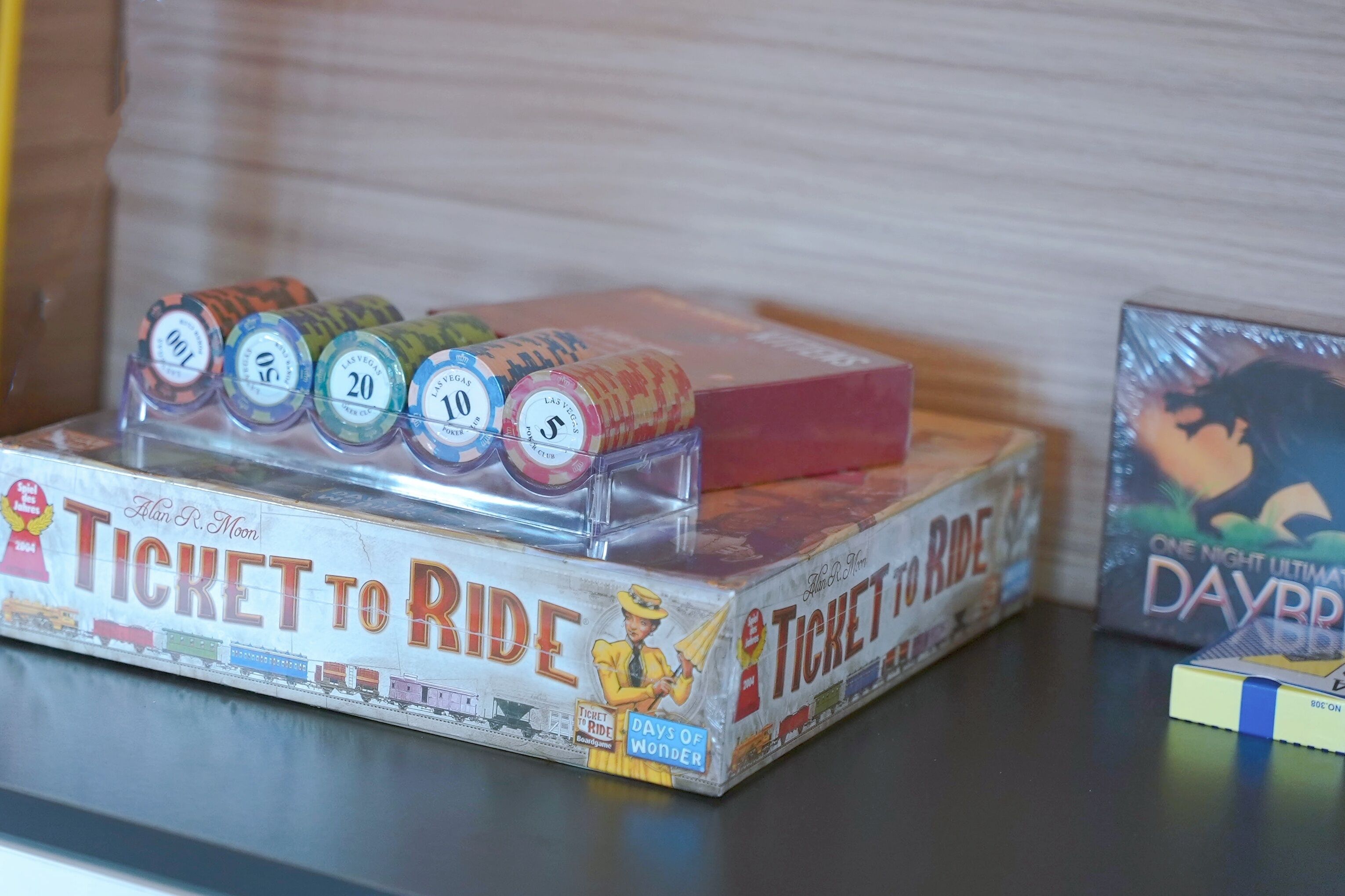 A board game titled "Ticket to Ride" with dice and game pieces on a table.
