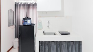 A compact kitchen with a built-in refrigerator, a sink, and a small countertop. - Good Price And Homey 2Br At Loftvilles City Apartment (South Tangerang)