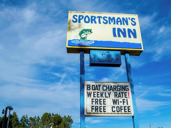 Letrero del Sportsman's Inn anunciando carga para embarcaciones, Wi-Fi gratuito y café de cortesía.