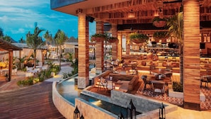 Un resort con zona de estar al aire libre, piscina y bar.