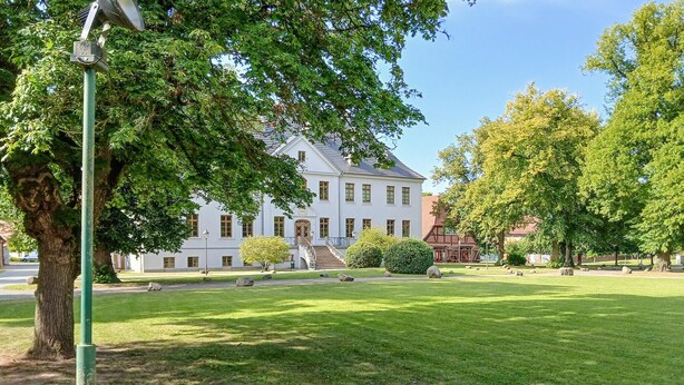 A large, white building with a symmetrical facade, a central entrance, and a well-maintained lawn with trees and shrubs. - 2 bedroom awesome home in Dobbin (Dobbin)