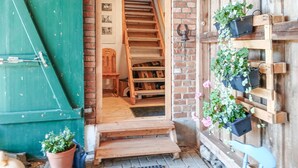 A wooden staircase leading to a room with a brick wall, a wooden bench, and potted plants. - 2 bedroom awesome home in Dobbin (Dobbin)
