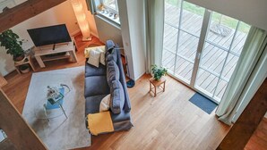 A spacious living room with a large sofa, a TV, and a wooden floor. - 2 bedroom awesome home in Dobbin (Dobbin)
