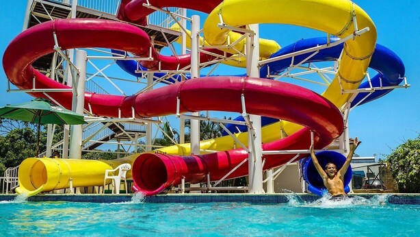 Un parque acuático con múltiples toboganes en colores rojo, amarillo y azul.