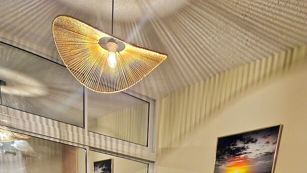 A bedroom with a bed, a mirror, a painting, and a ceiling light fixture. - Lila House (Samaná)