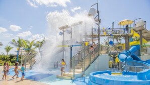 Un parc aquatique doté d’un grand toboggan aquatique, d’une piscine à vagues et d’un espace de jeux avec des toboggans et des jeux d’eau.