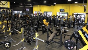 Une salle de sport équipée de divers appareils de musculation et de machines de cardio.