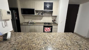Een koelkast, een oven, een kookplaat, een koffiezetapparaat/waterkoker