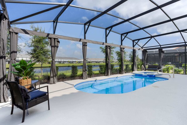 An outdoor swimming pool with a covered area, a chair, and a plant.