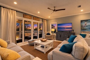 Ein Wohnzimmer mit Fernseher, Sitzgelegenheit und Blick ins Freie.