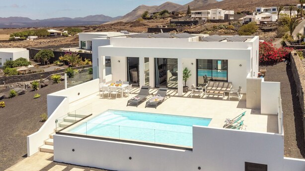 A modern villa with a rooftop pool, surrounded by a landscaped garden and a mountainous backdrop. - CAPRICA by Buenavilla| Indulge in Serene Opulence at Las Breñas, Lanzarote. (Las Breñas)