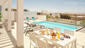 A rooftop dining area with a pool, white furniture, and a clear view of the surrounding landscape. - CAPRICA by Buenavilla| Indulge in Serene Opulence at Las Breñas, Lanzarote. (Las Breñas)