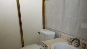 Une salle de bain équipée de toilettes, d’un lavabo et d’un meuble-lavabo.