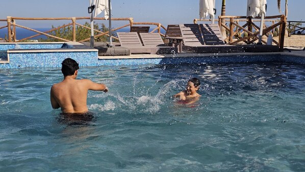 Outdoor pool, open 9:00 AM to 6:00 PM, pool umbrellas, pool loungers