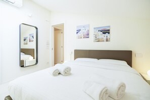 Una habitación de hotel con una cama, un espejo y dos cuadros colgados en la pared.