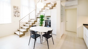 A modern kitchen with white cabinets, a built-in oven, and a staircase leading to an upper level. - Corte Farina - Modern and central residence (Verona)