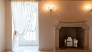 A room with a fireplace, a window with curtains, and a wall-mounted light fixture. - Fabulous residence overlooking Piazza Erbe (Verona)