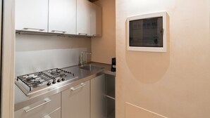 A kitchen with a gas stove, stainless steel cabinets, and a window. - Fabulous residence overlooking Piazza Erbe (Verona)