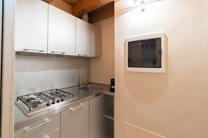 A kitchen with a gas stove, stainless steel cabinets, and a window. - Fabulous residence overlooking Piazza Erbe (Verona)