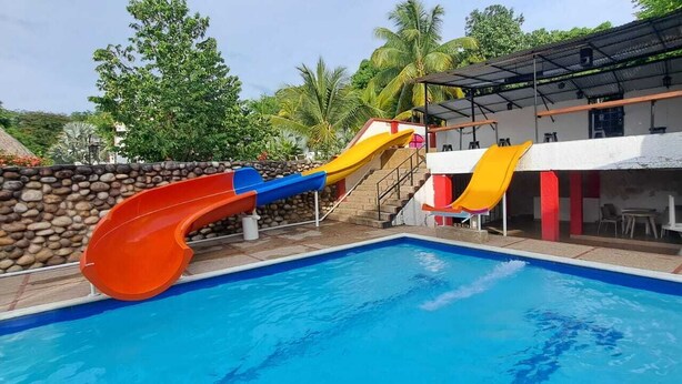 Ein Pool mit Rutschen und ein Gebäude mit Außenbereich.