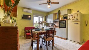 A kitchen with a dining table, chairs, and a ceiling fan.