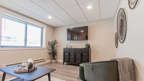 Een moderne woonkamer met een bank, een salontafel, een kast en een groot raam.