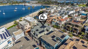 A coastal residential area with houses, a beach, and boats. - Steps to Water - Newly Built Bayside Dream | Patios, Fire Pit, Bay Views, Garage (San Diego)