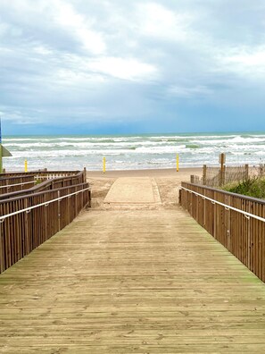 A wooden boardwalk leading to a sandy beach with waves in the background. - SURFSIDE ESCAPE: NEW MODERN RENO, Partial Ocean View, Heated Pool, Pet Friendly (South Padre Island)
