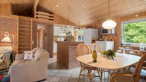 Ein gemütliches Blockhaus-Interieur mit Essbereich, Küche und Wohnzimmer.